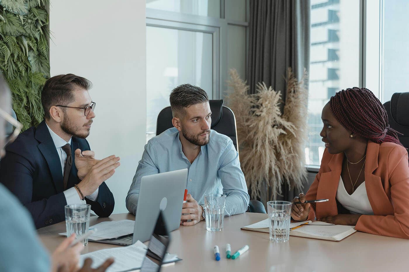 Coaching vs mentoring concept: coworkers collaborate at a conference table