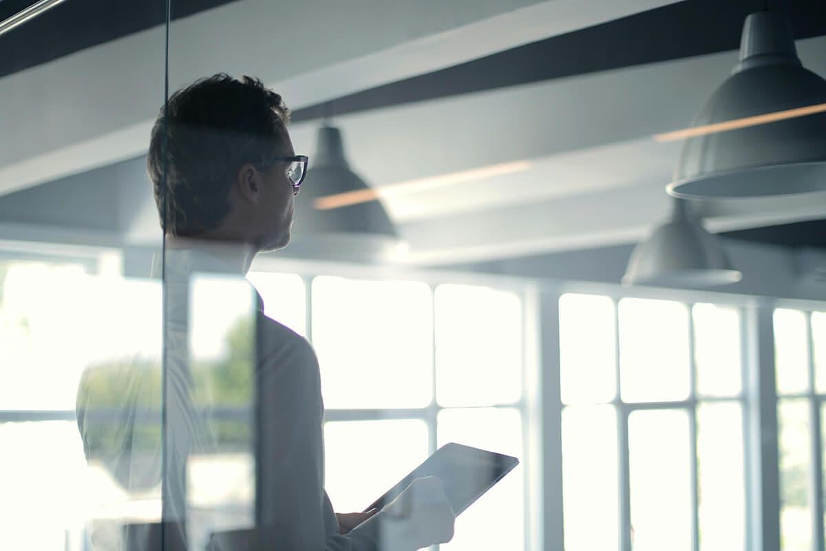 man looking at iPad in a modern office