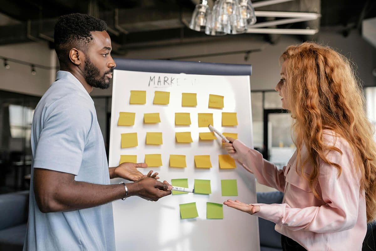 Colleagues planning with sticky notes on a whiteboard