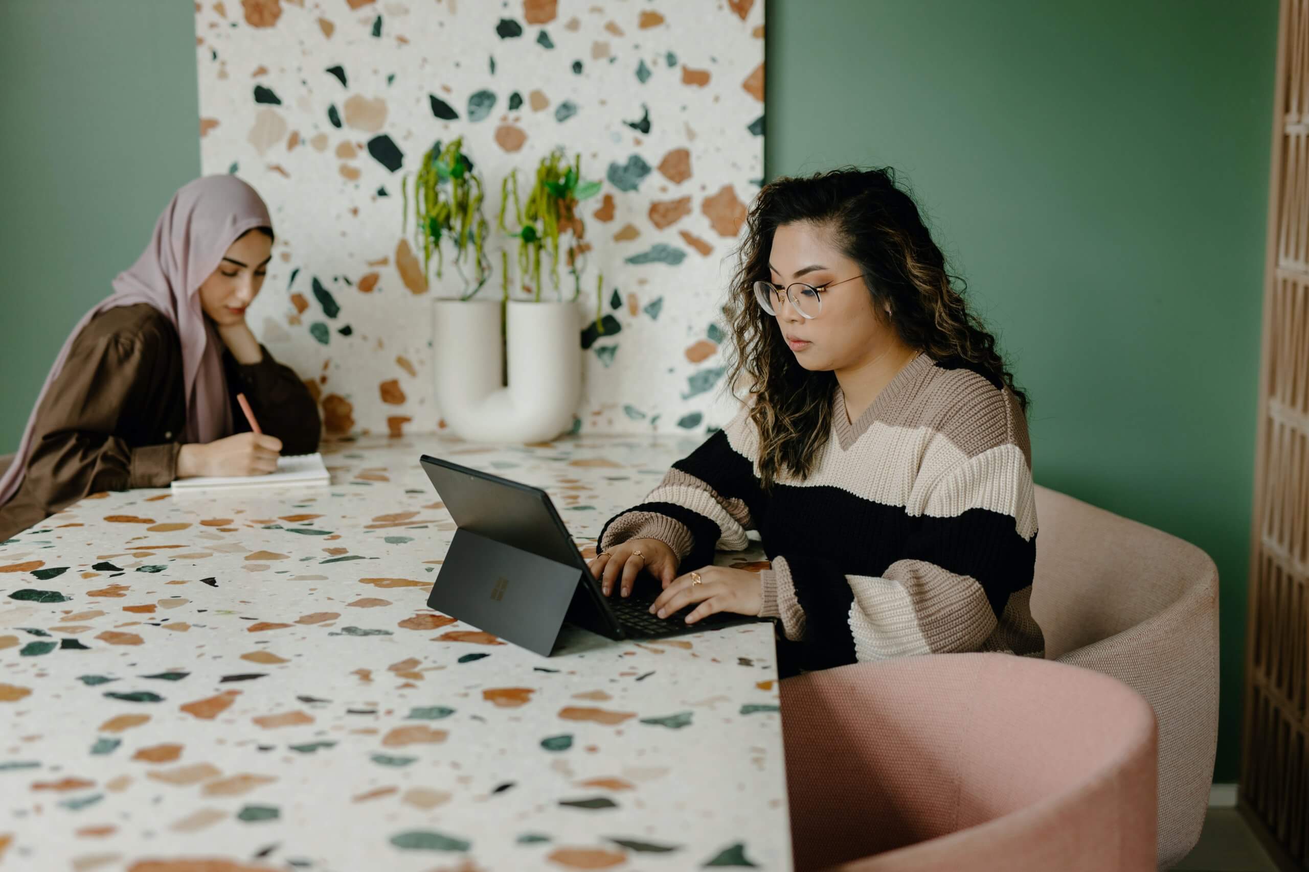 Two colleagues working on goals at a shared table